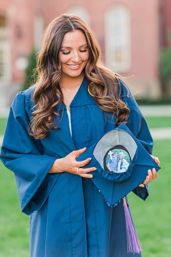 Caylie Simmons holds her graduation cap with a picture of her and her brother inside.