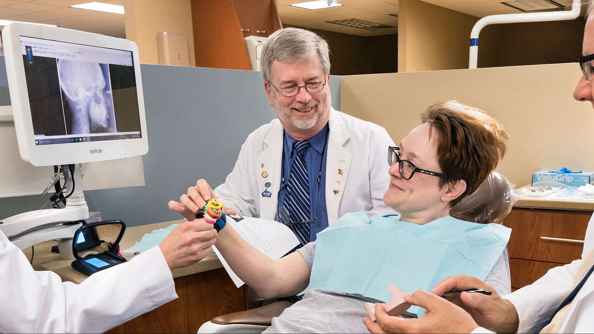 WVU School of Dentistry faculty work with a patient and student dentist. 