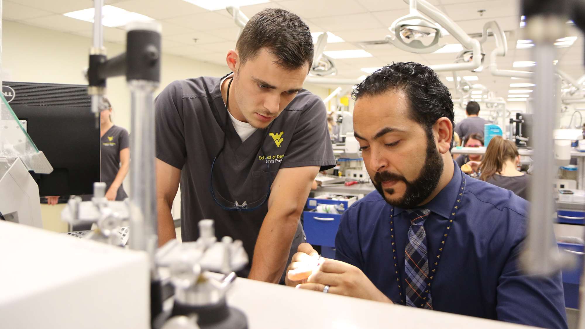 A faculty member and student examine dentures