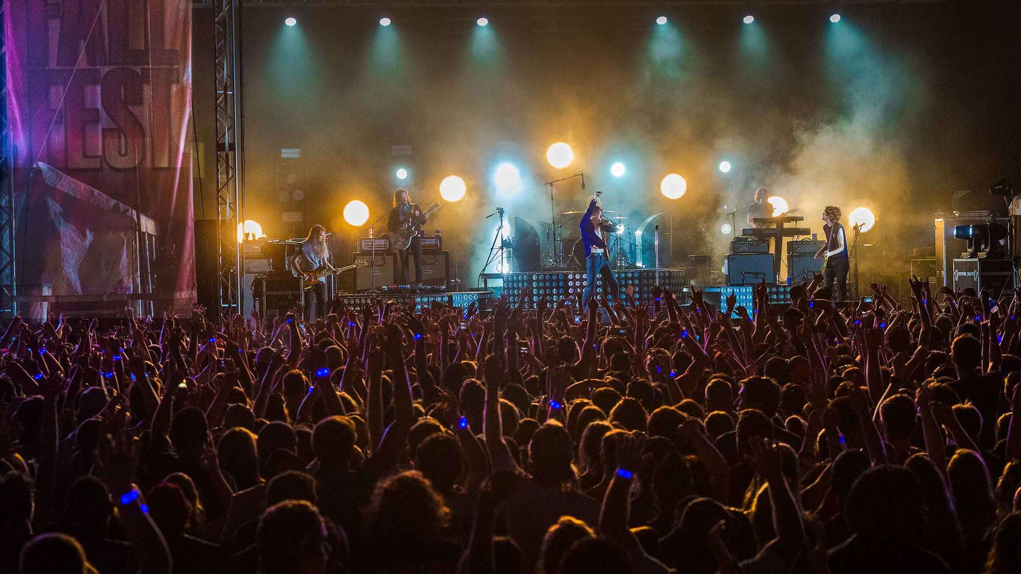 An audience cheering on a musical act at Welcome Week's Fallfast concert.