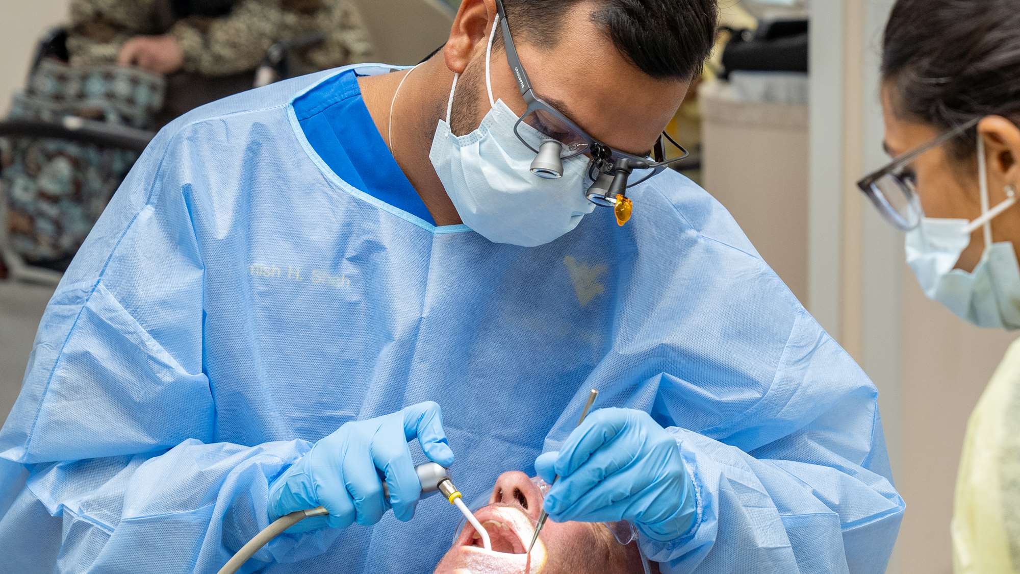 Dental students treat a patient in the main student clinic.