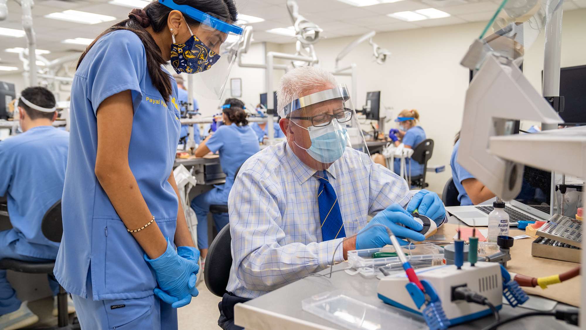 Dr. Bryan Dye works with a DDS student in the simulation lab.