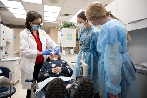 Pediatric dentist Dr. Gina Graziani works with students in the pediatric clinic.