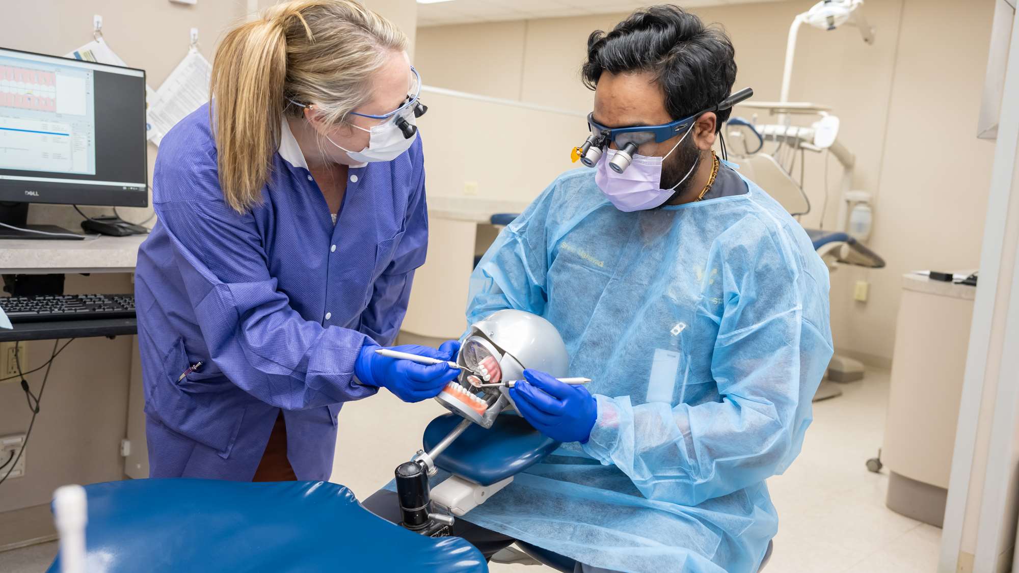A dental student works in the simulation lab. 